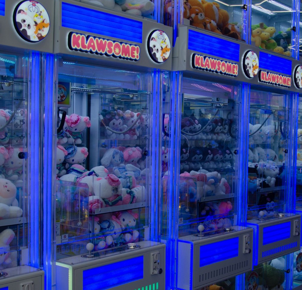 Klawsome plush claw machines lined up with blue glow