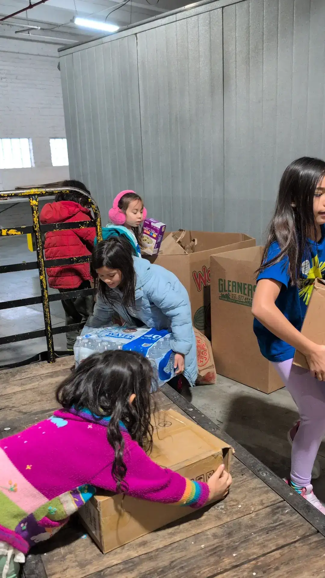 Kids organizing food and water donations at Gleaners