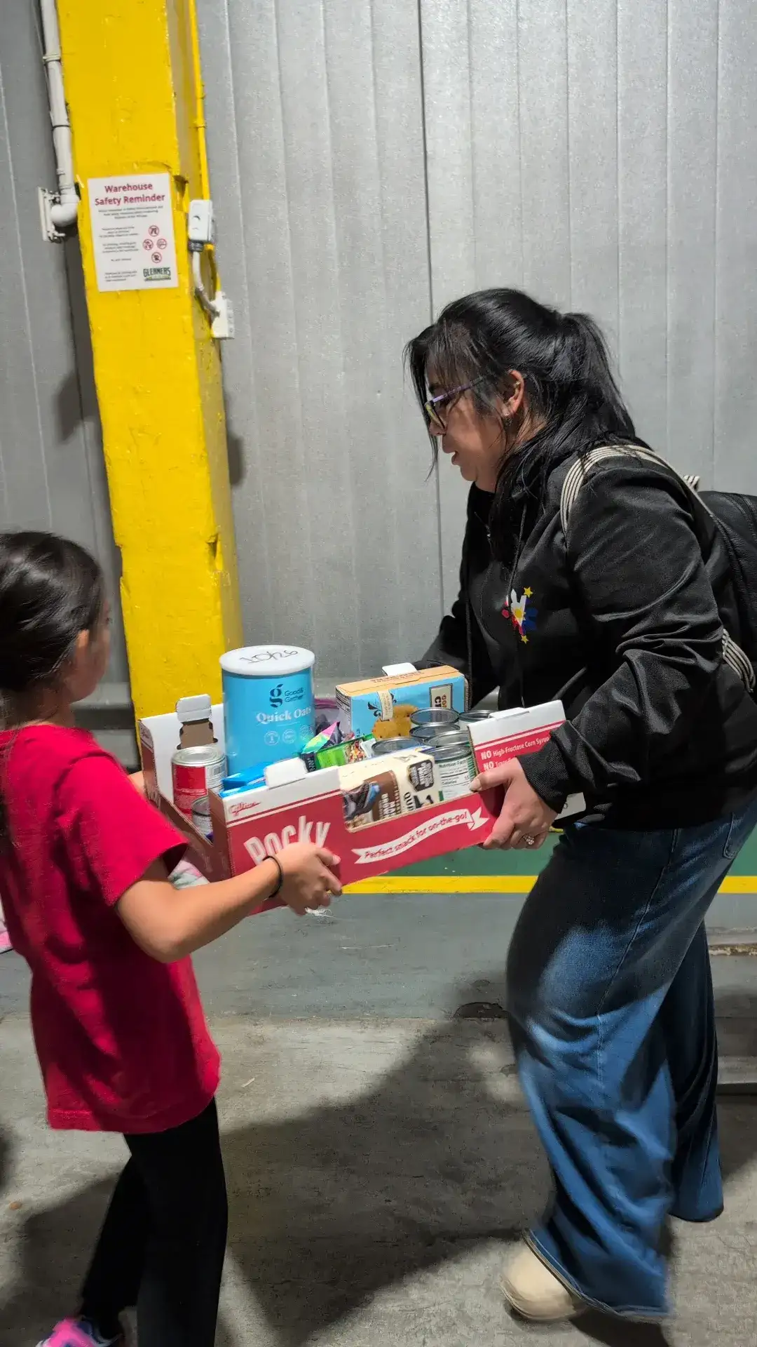 Carrying a box of donations together