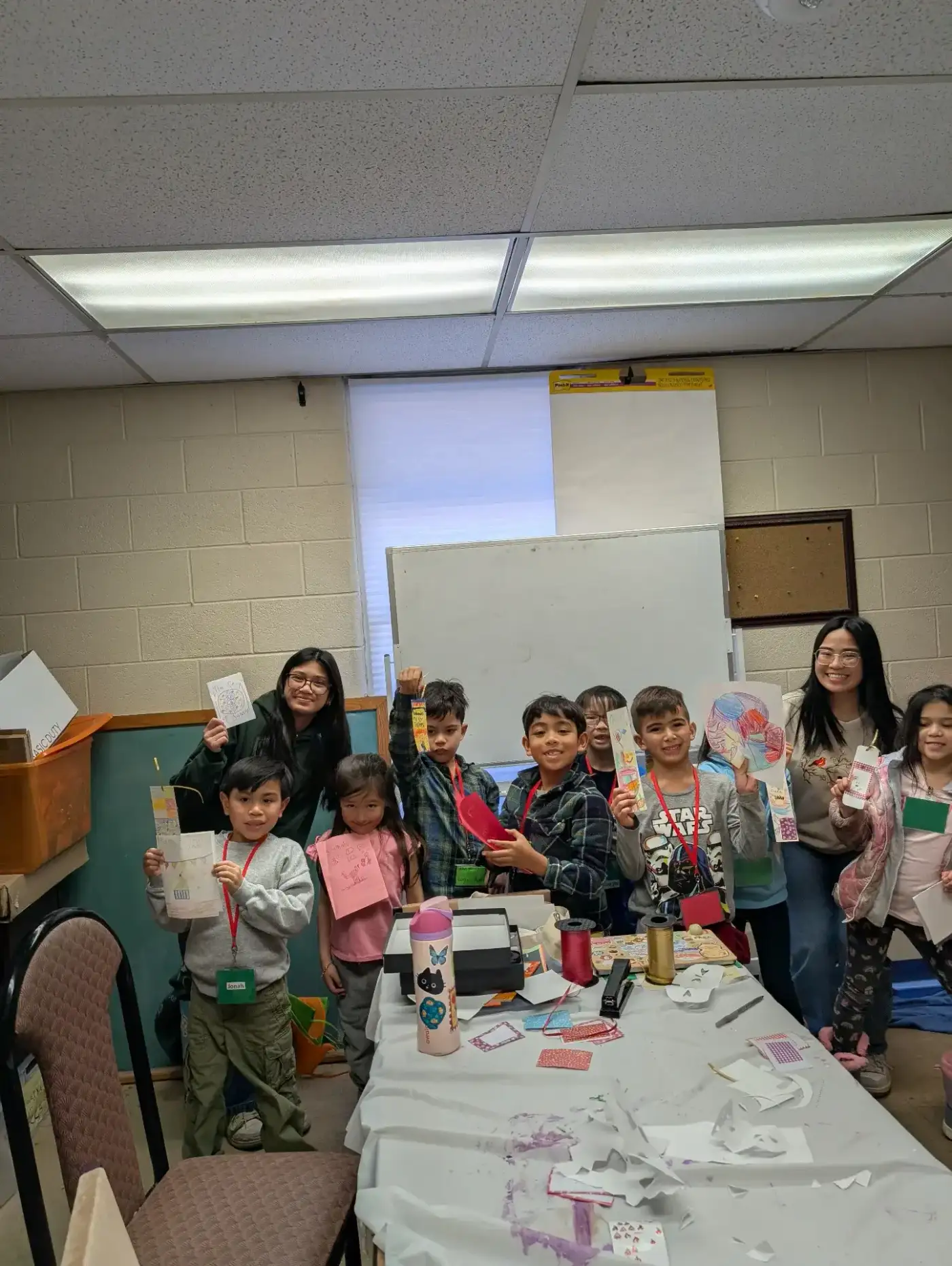 Kids proudly showing off their handmade cards and bookmarks