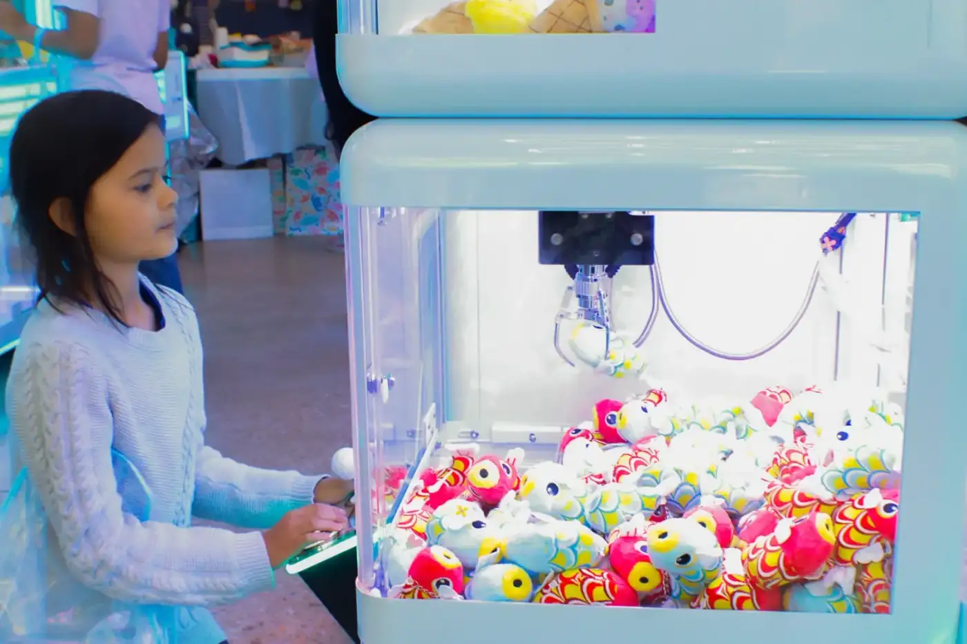 Trying her luck on the koi fish claw machine