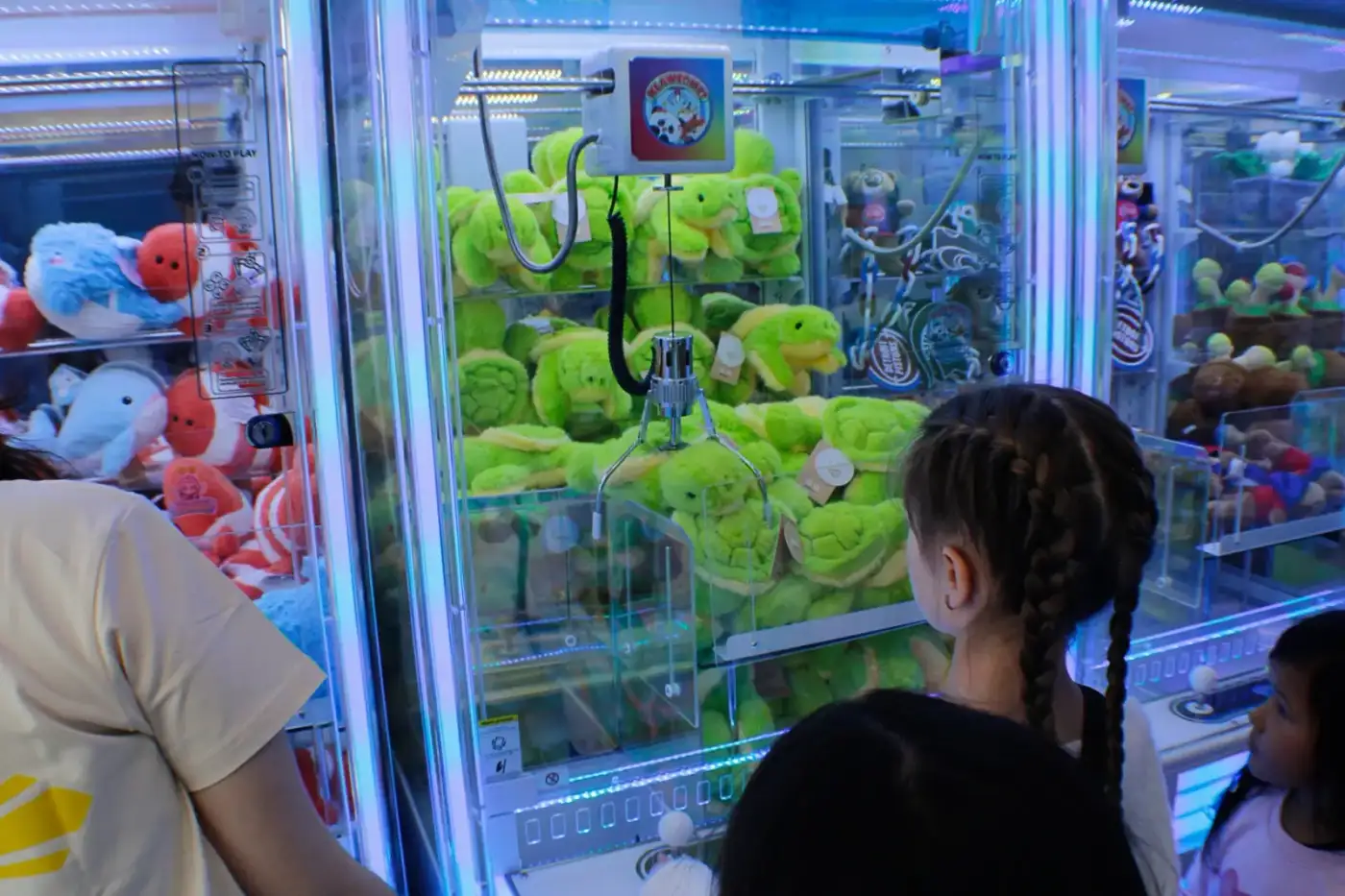 Kids gathered around the green turtle plush machine